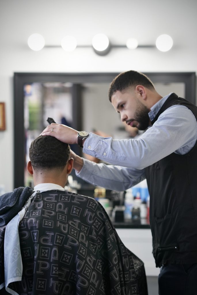 Waves with a taper fade cut by Nikko at The Parlor Barbershop in Libertyville